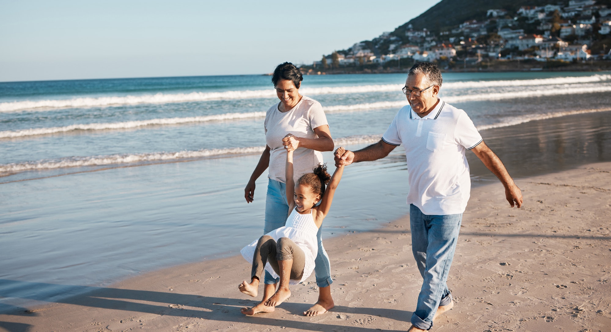 Shot of a little girl spending time with her grandparents at the beach